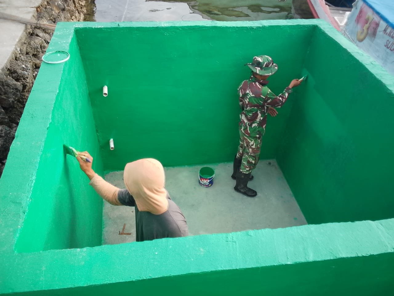 Penyelesaian Pengecatan Bak Air oleh Satgas TMMD Ke-129 di Desa Umbele